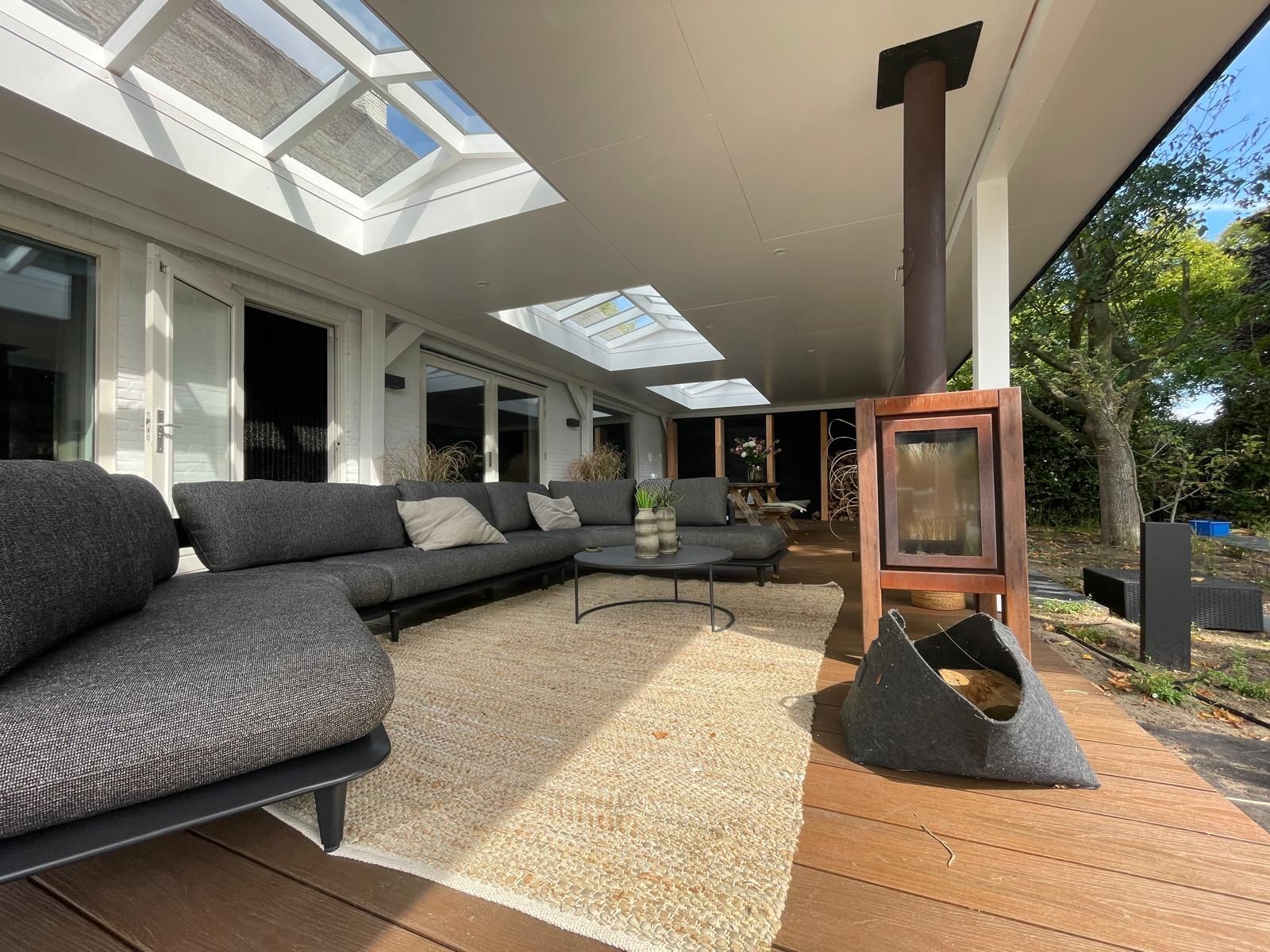 Overdekt terras met zitgelegenheid, open haard en dakramen.