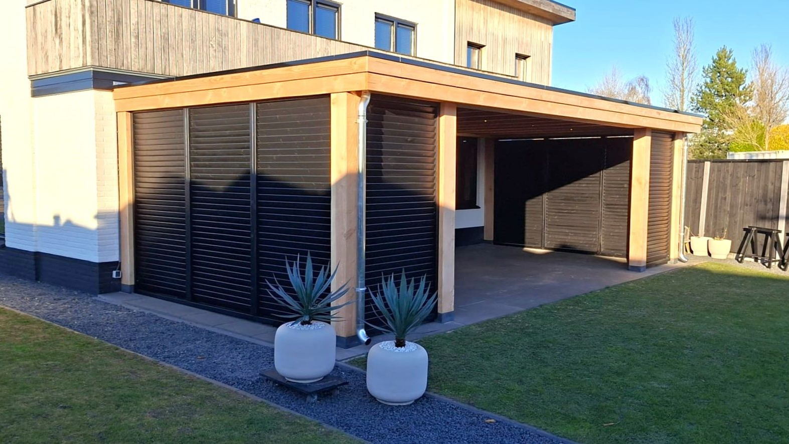Luxe overkapping met zwarte shutters
