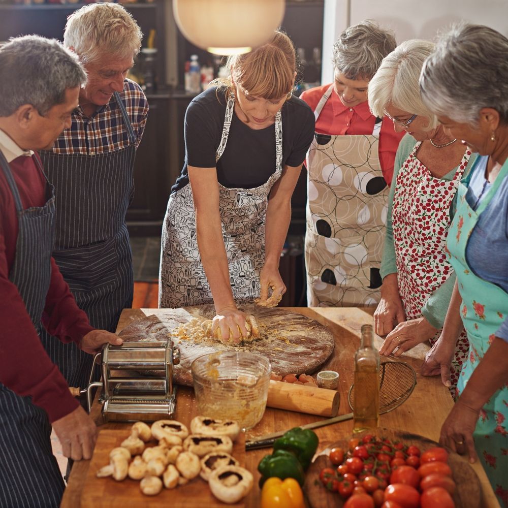 A group of people are standing around a table preparing food.