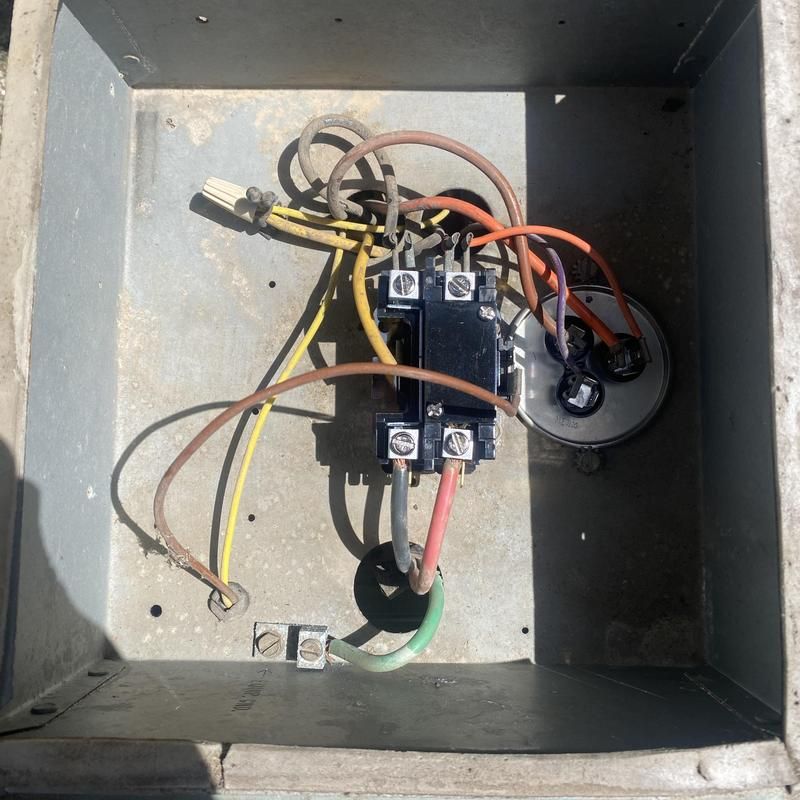 Metal box with electrical components: capacitor, contactor, wires.