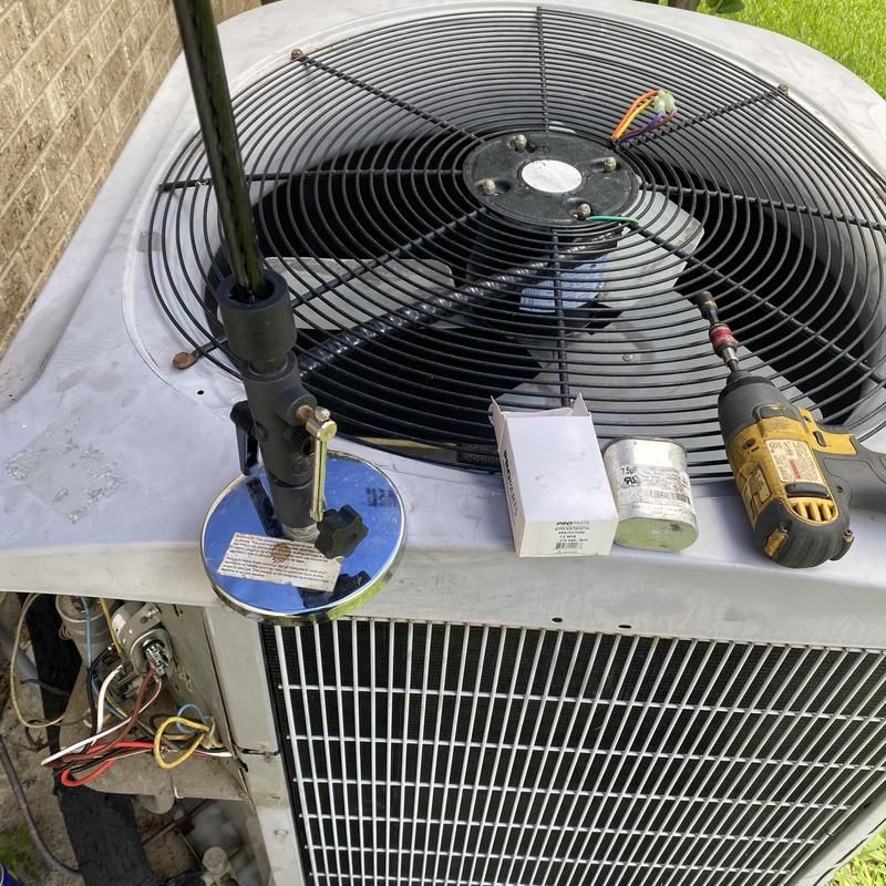 Air conditioner being repaired with parts and tools on top.