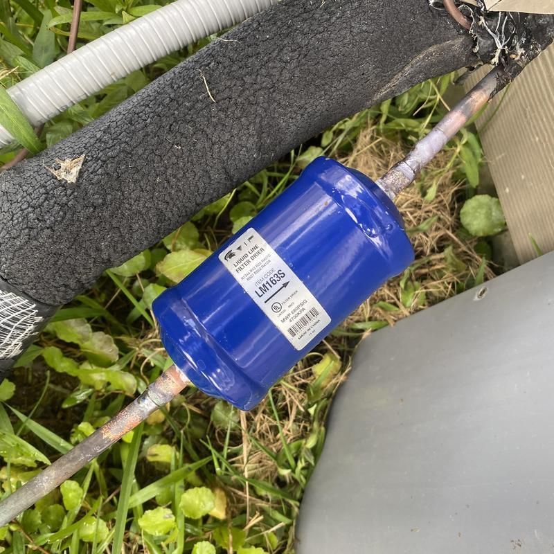 Blue air conditioner filter on copper pipe.