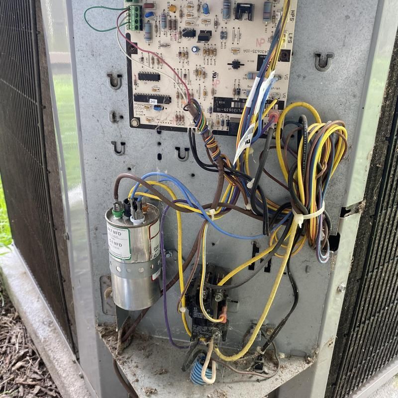 Open air conditioner unit, wires and circuit board visible.