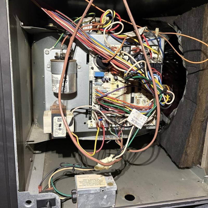 Open view of HVAC electrical components with wires, circuits, capacitor, and transformer.