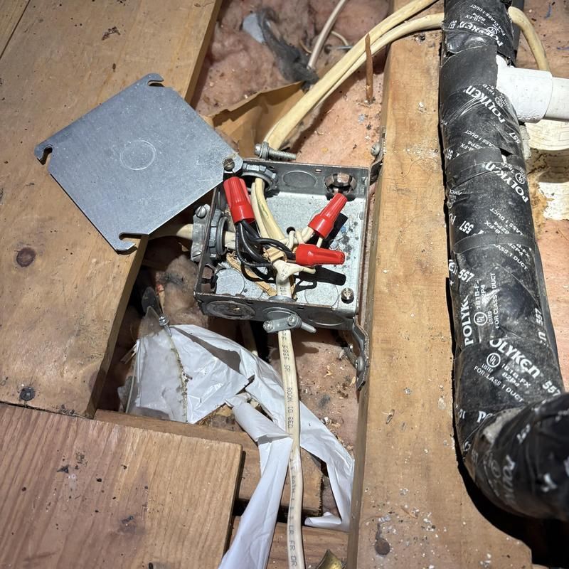Electrical junction box with wires and wire connectors; exposed framing.