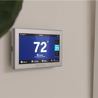 Smart thermostat on a wall displaying 72 degrees. Current setting is 71 degrees.