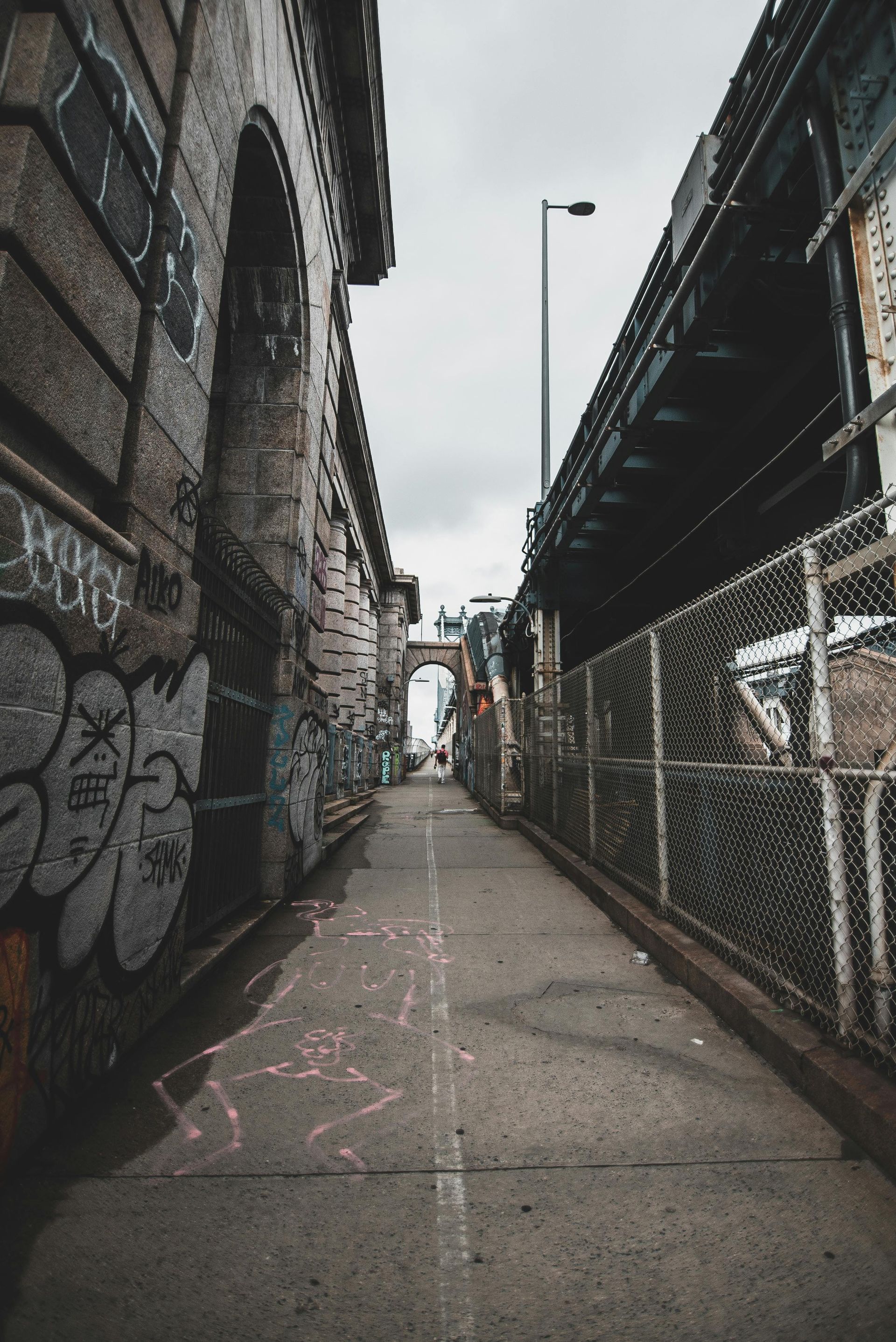 A narrow alleyway between two buildings with graffiti on the walls