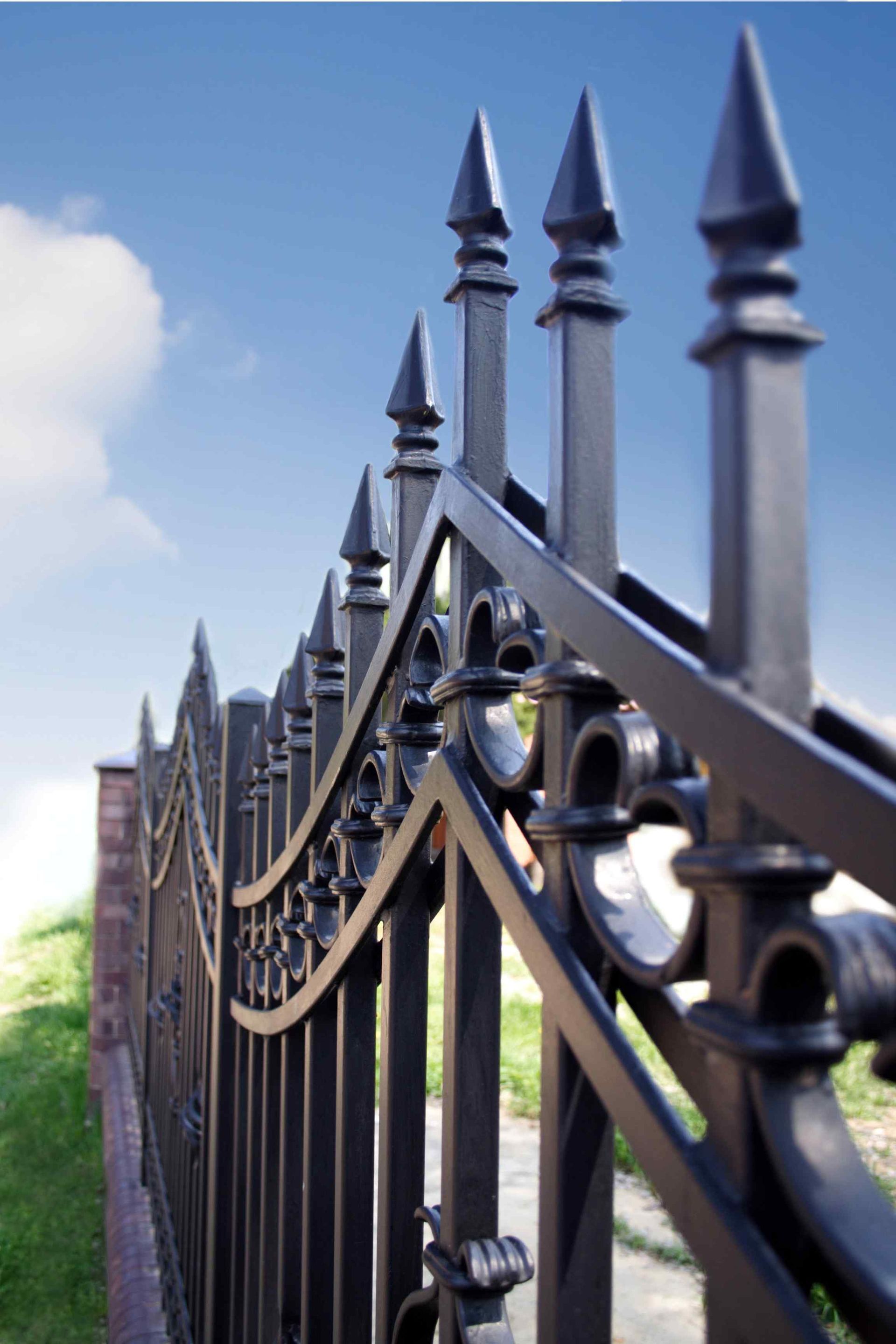 A wrought iron fence with a blue sky in the background