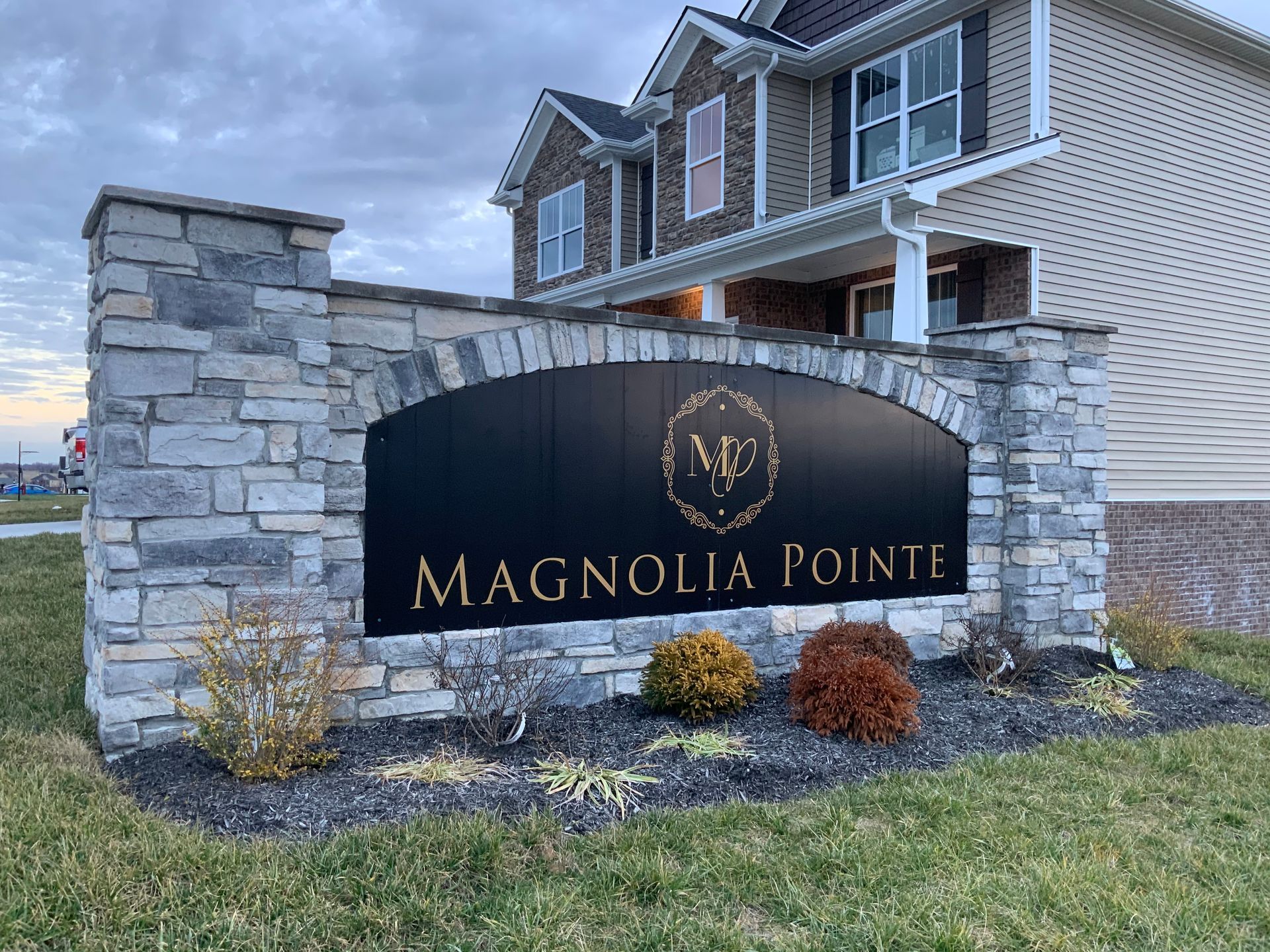 A sign for magnolia pointe is in front of a house.