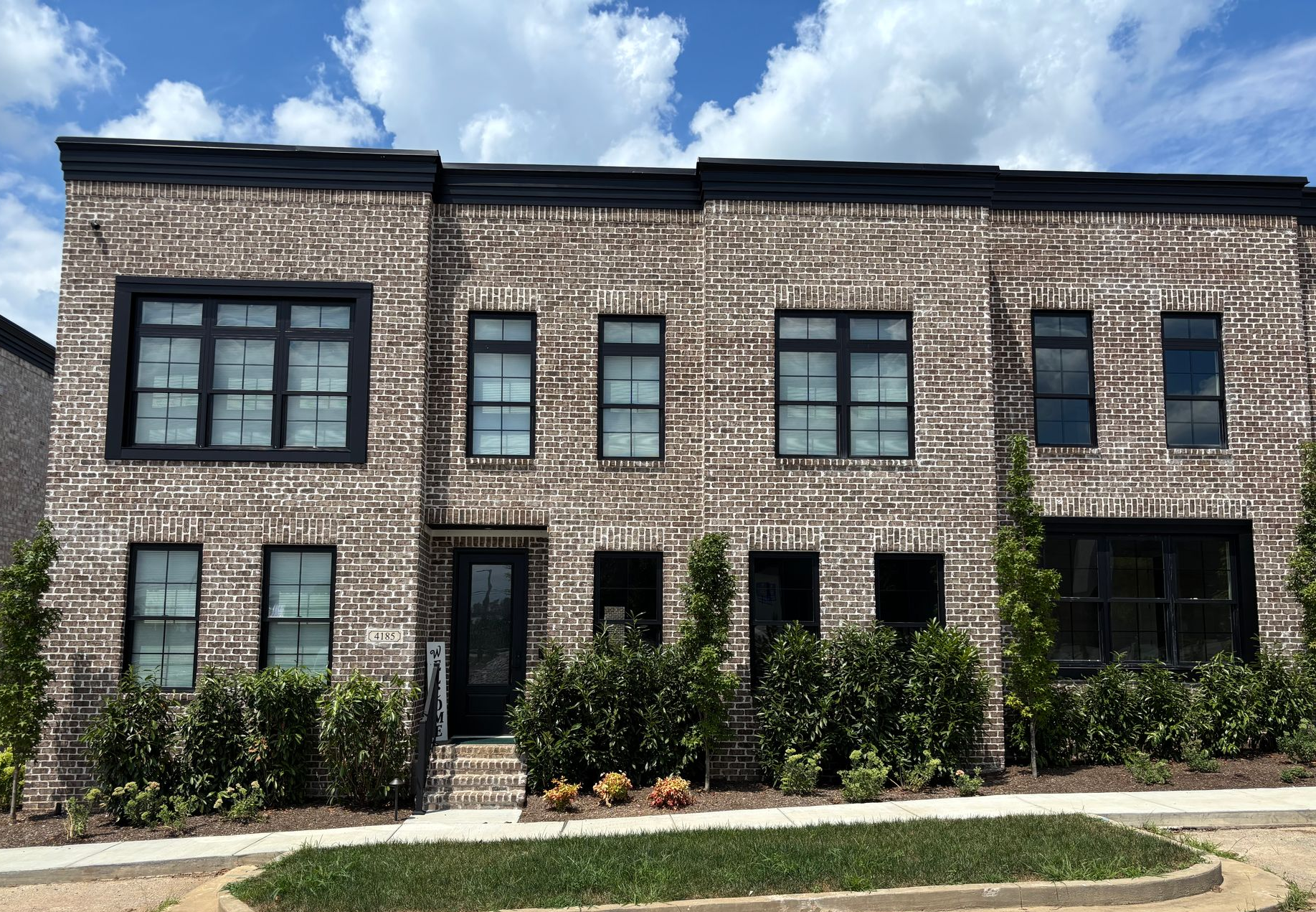 a brick house with a porch and a white truck parked in front of it .