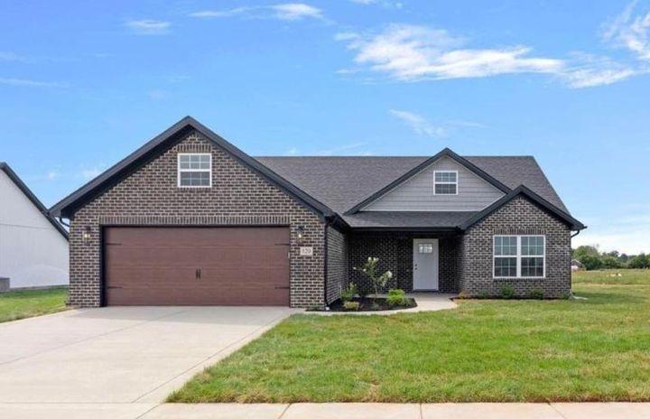 a brick house with a porch and a white truck parked in front of it .