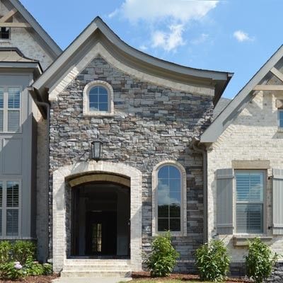 A house with a stone facade and a curved roof