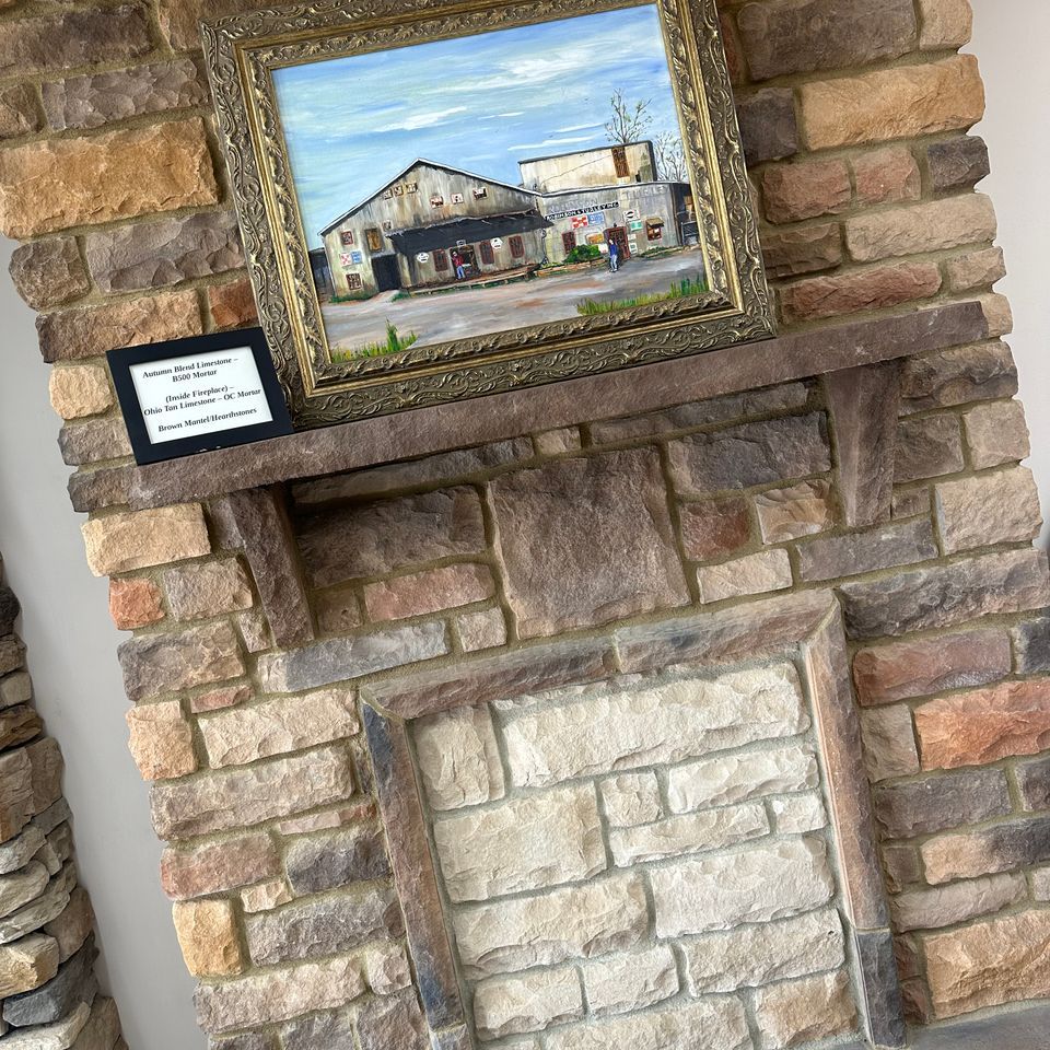 a brick fireplace with a framed picture on top of it