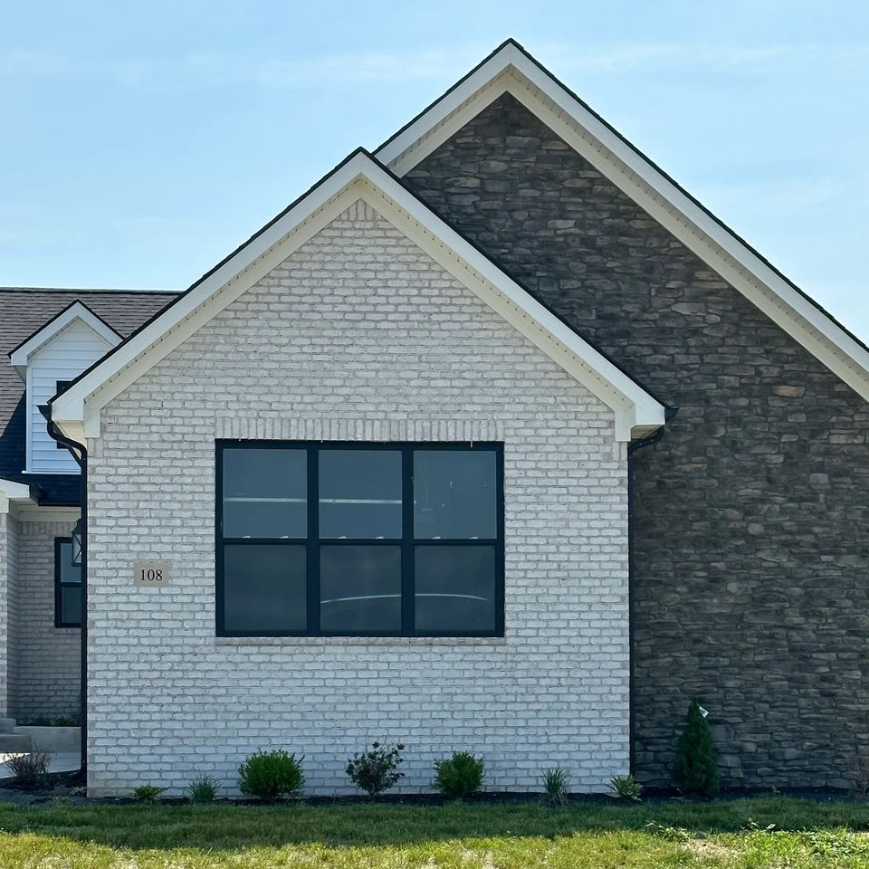 a white brick house with a black window