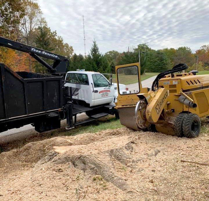 A stump grinder next to a truck.