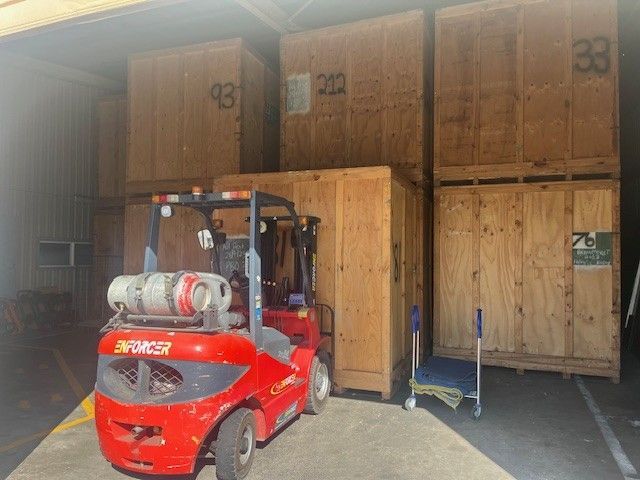 A red forklift moving wooden storage crates — Ballina Removals & Storage in Alstonville, NSW