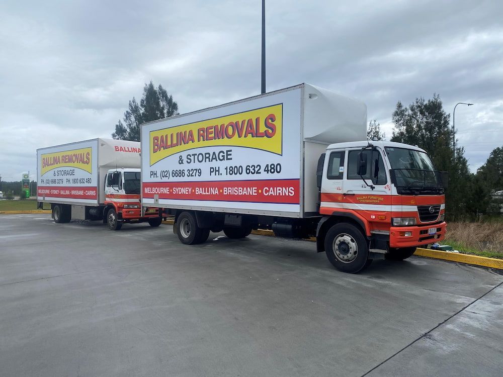 Two Moving Trucks Are Parked Next to Each Other in a Parking Lot — Ballina Removals & Storage in Alstonville, NSW