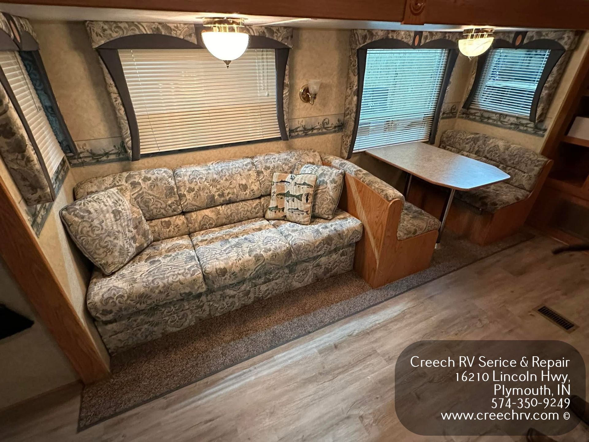 RV roof with air conditioner, vents, and sealant in a repair shop.