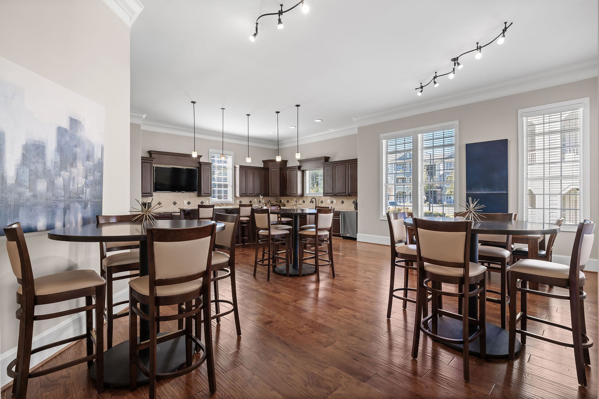 A large clubhouse kitchen with tables and chairs in it at Marquis Ellis Crossing offers apartments in Durham, NC.