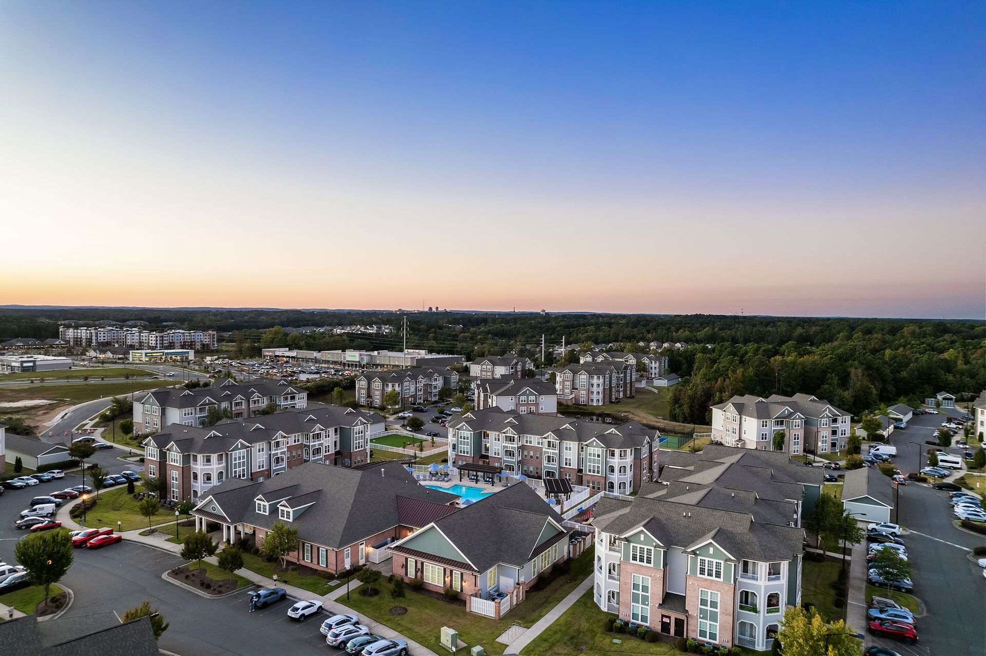 An aerial view of a large apartment complex at sunset at Marquis Ellis Crossing offers pet-friendly apartments in Durham, NC.
