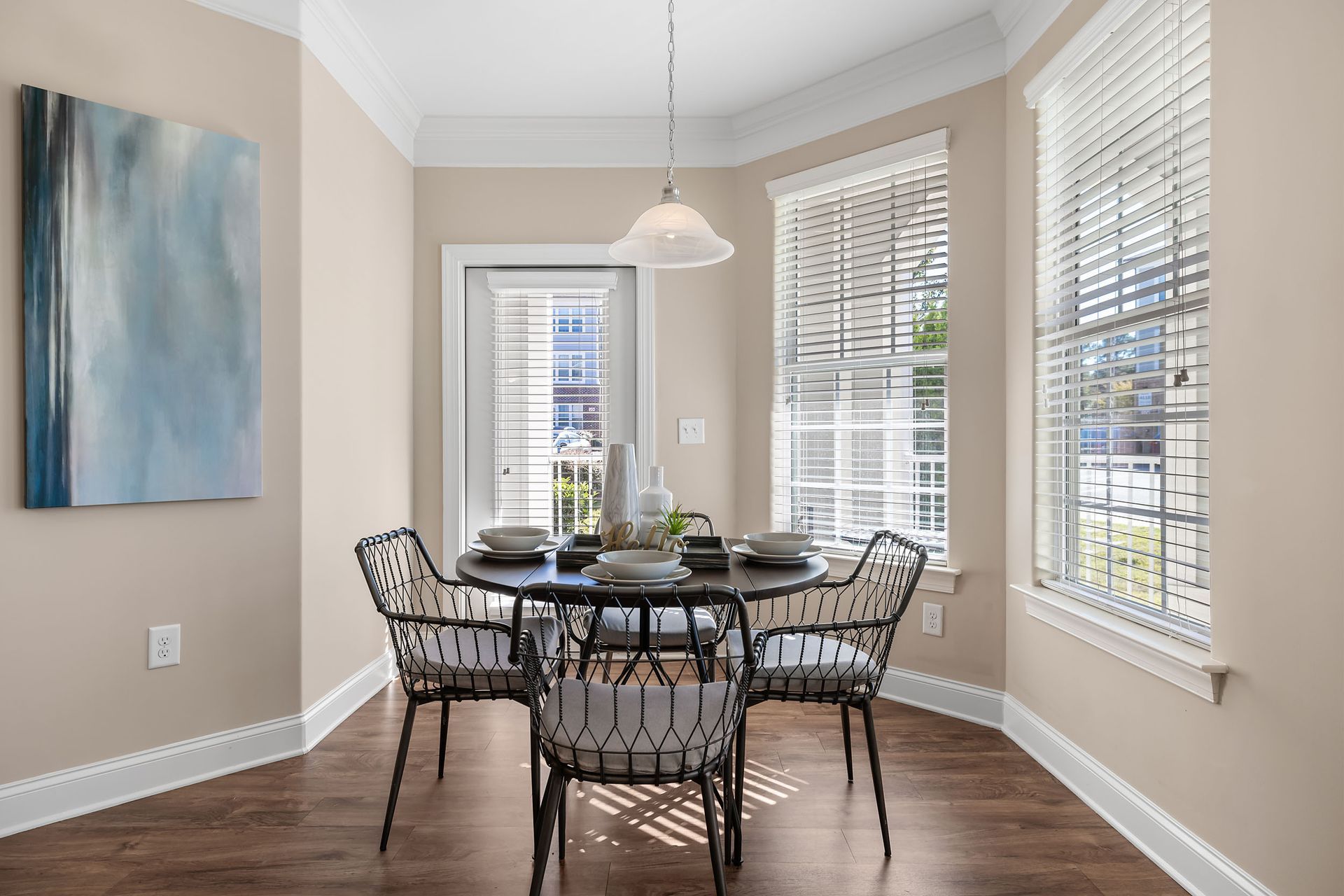 A dining room with a table and chairs and a painting on the wall at Marquis Ellis Crossing offers apartments for rent near Duke University, Durham, NC.