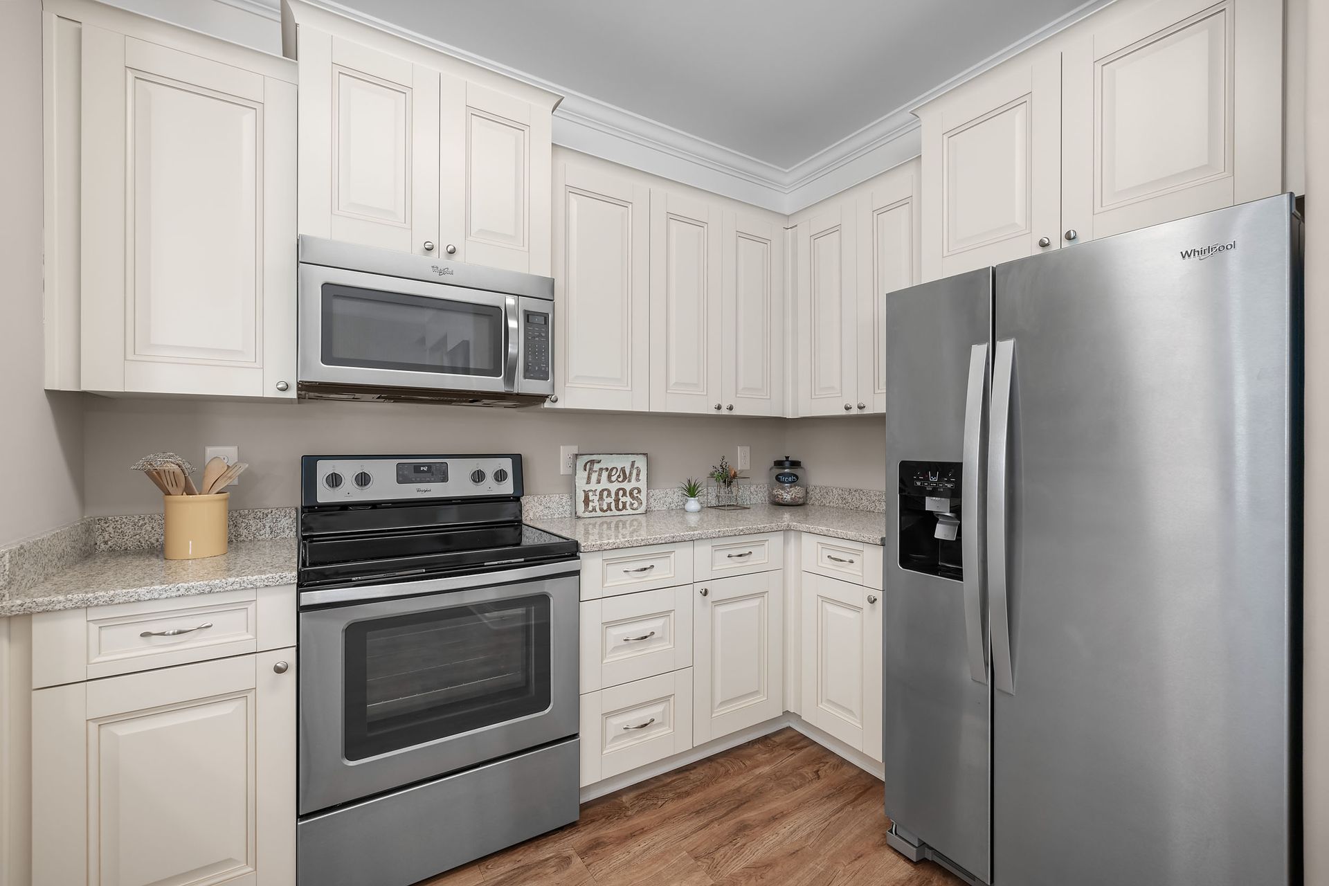 A kitchen with stainless steel appliances and white cabinets at Marquis Ellis Crossing offers apartments for rent in Durham, NC.