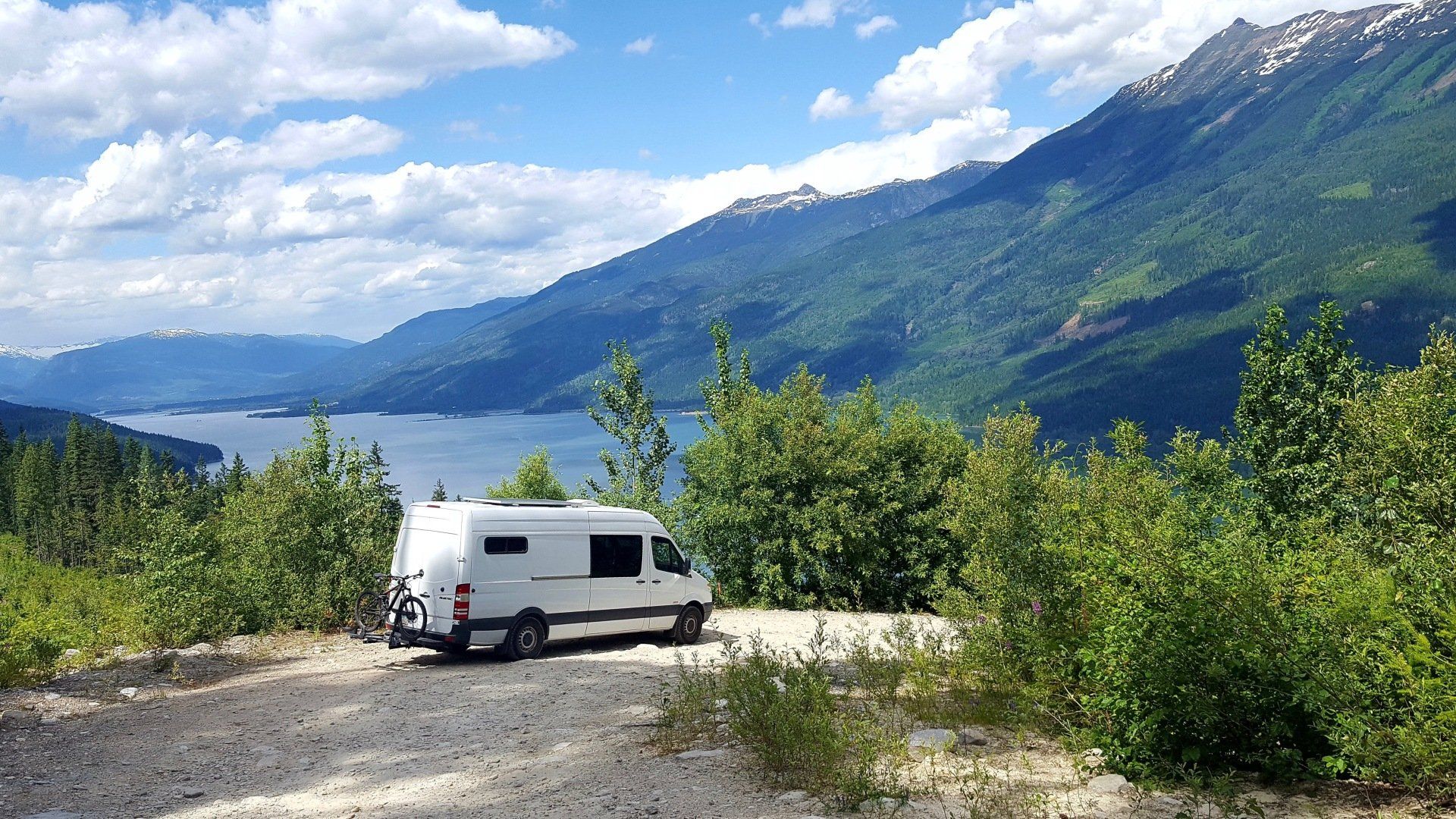White Sprinter van parked at a glacier lake