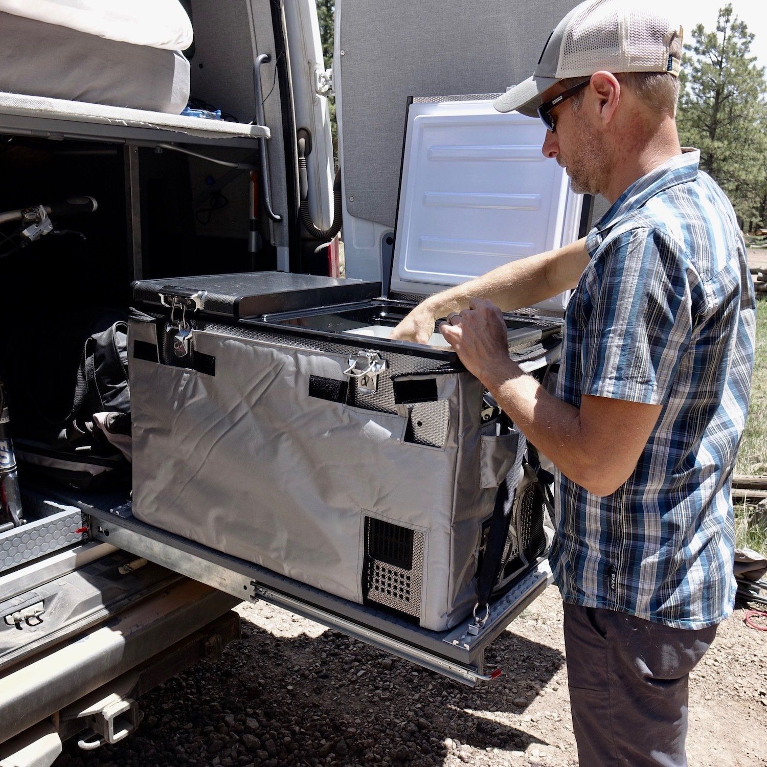 A guy pulling out a refrigerator drawer slide from the rear of his van