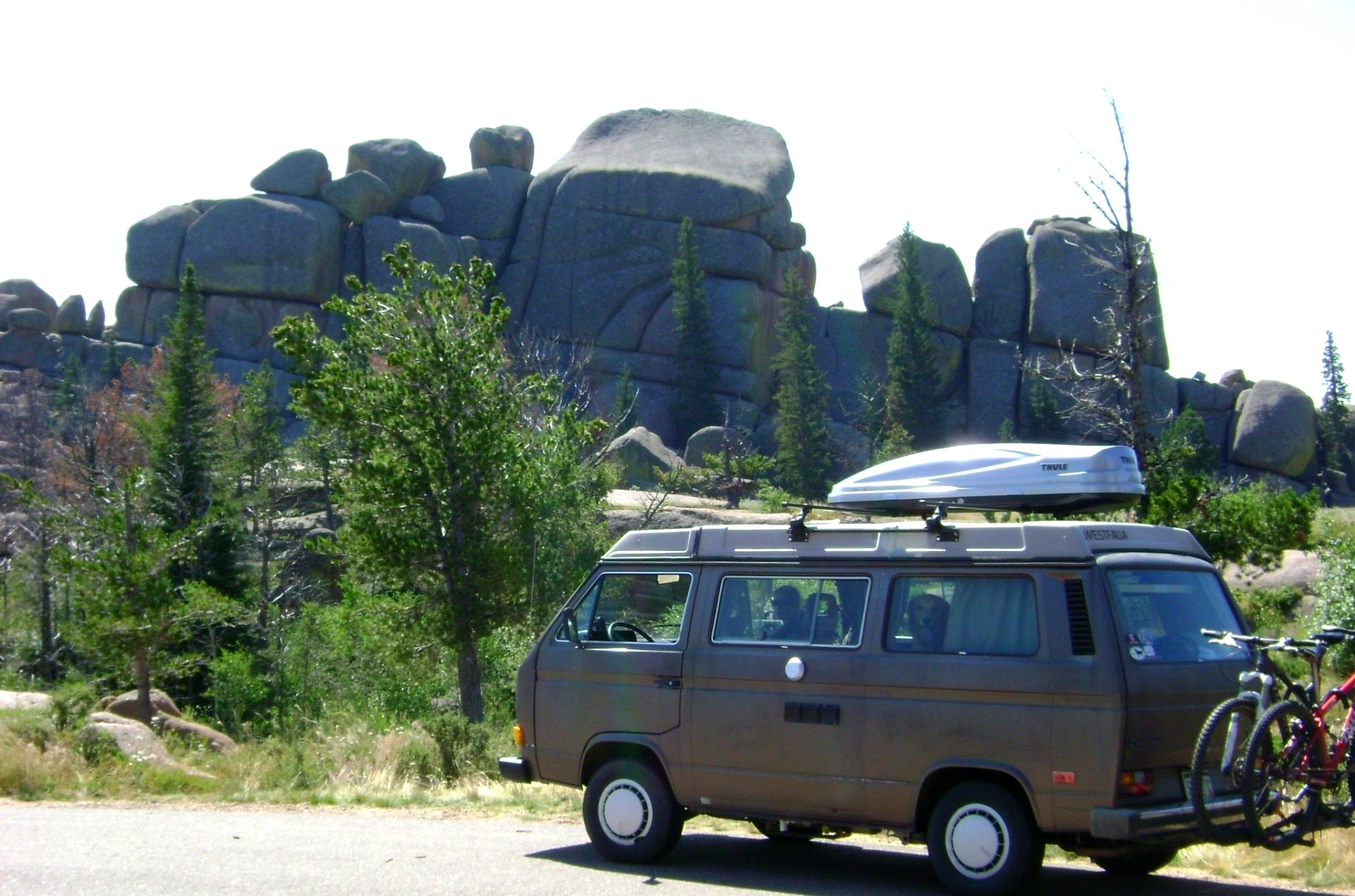 Brown VW camper van with rock formations in the background