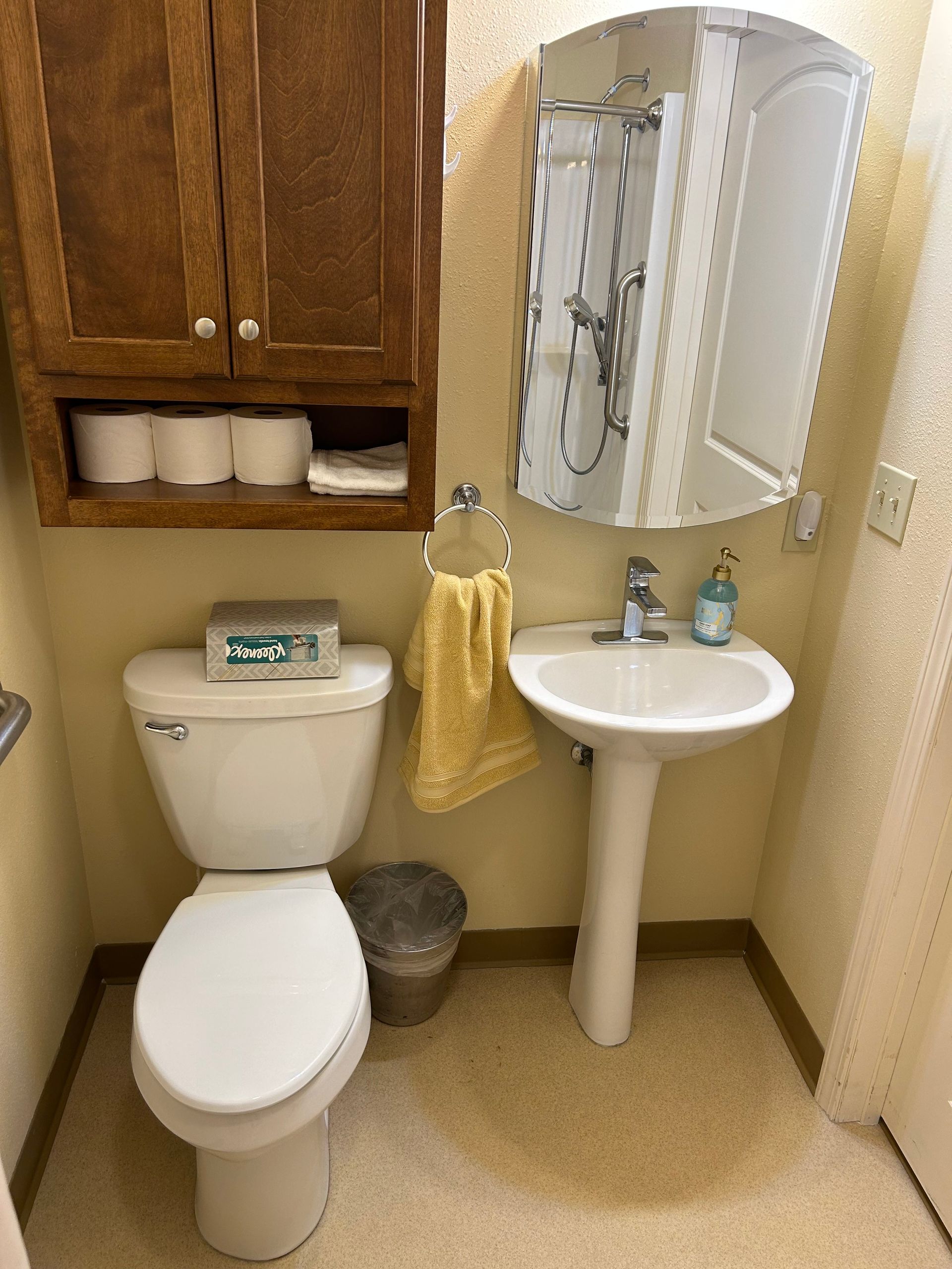 A bathroom with a toilet , sink and mirror