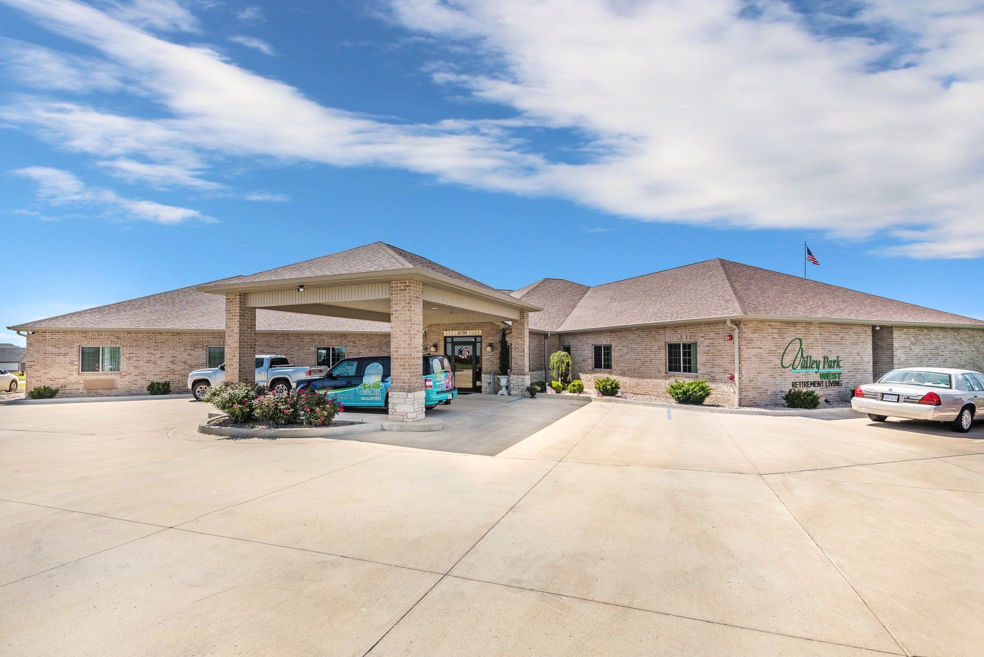 A large brick building with cars parked in front of it.