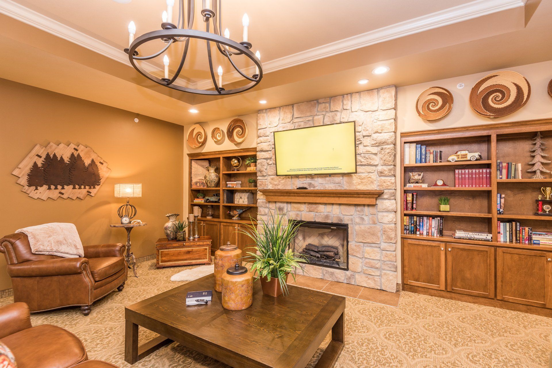 A living room with a fireplace , coffee table , chairs and a television.