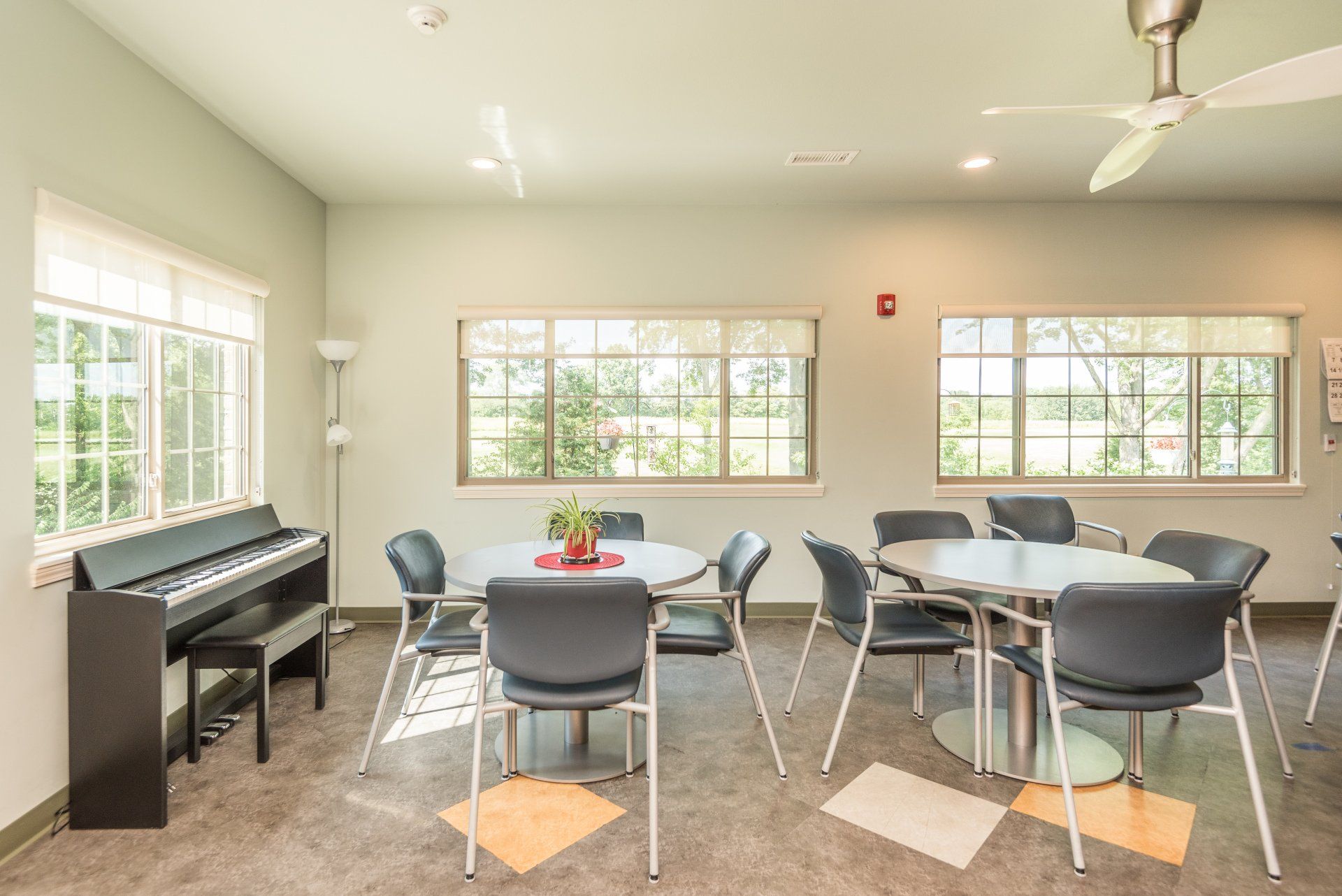 A room with tables and chairs and a piano.