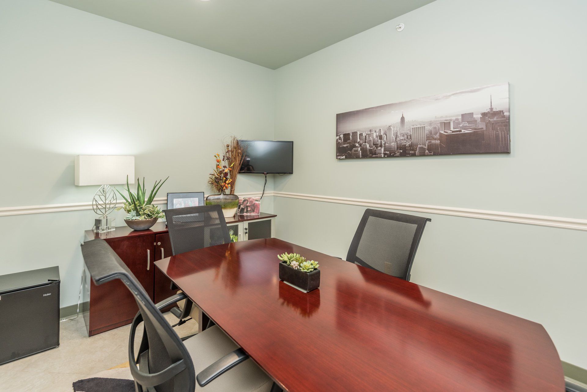 A conference room with a long wooden table and chairs.