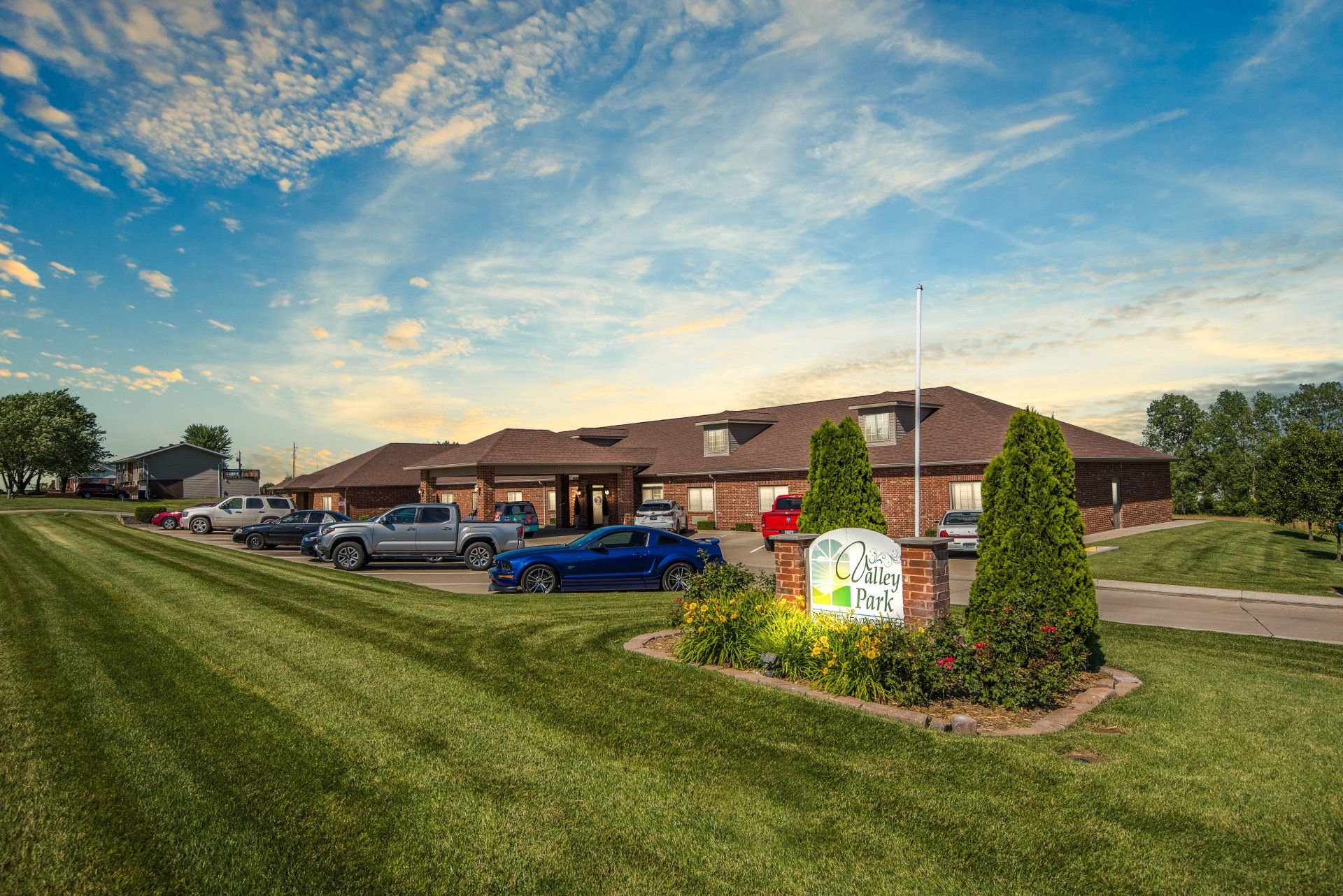 A large building with a lot of cars parked in front of it.