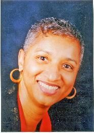 A woman wearing earrings and a red shirt is smiling for the camera.