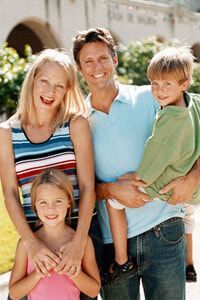 A family is posing for a picture together in front of a building.