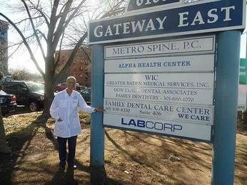 A man in a lab coat is standing in front of a sign for gateway east.