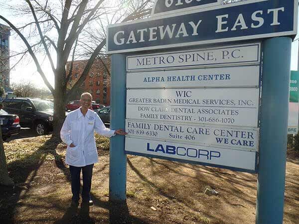 A man in a lab coat is standing in front of a sign that says gateway east