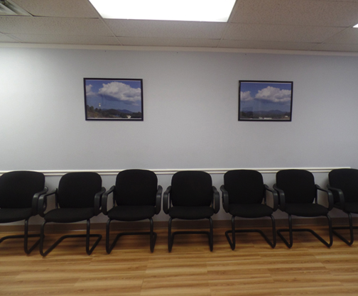 A row of black chairs in a waiting room