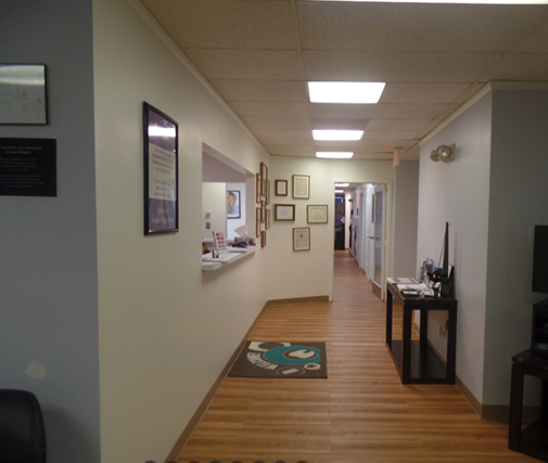 A long hallway with wooden floors and white walls