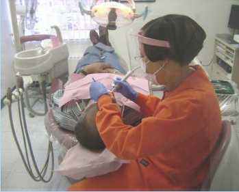 A dentist is examining a patient 's teeth in a dental office.