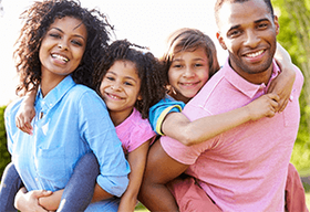 A family is posing for a picture together in a park.