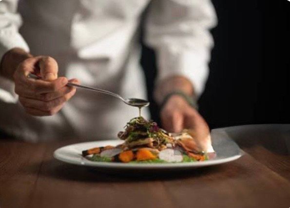 Hands of a group stacked together in a huddle, showing unity and teamwork.
