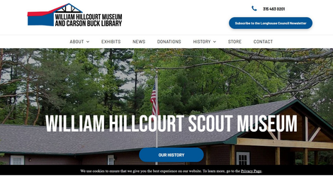 The william hillcourt scout museum website shows a picture of a log cabin surrounded by trees.