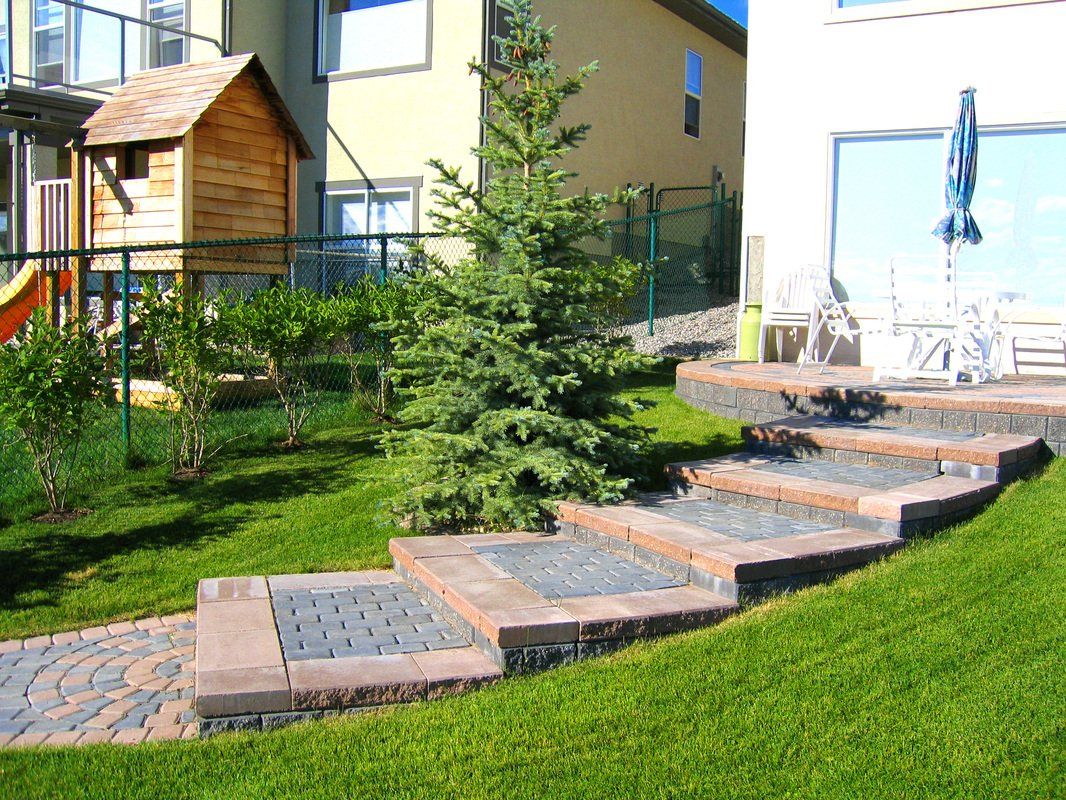 Paved stairs leading down from patio in a healthy lawn of grass