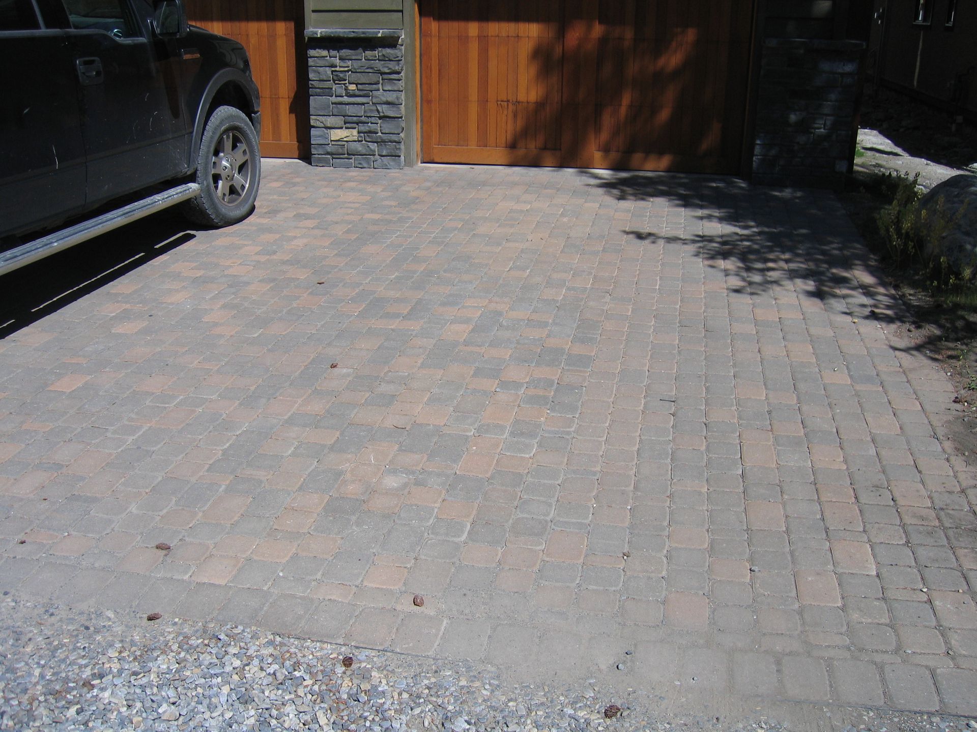 Long driveway and patio made of square paver stones installed in Victoria BC by Larix Landscape