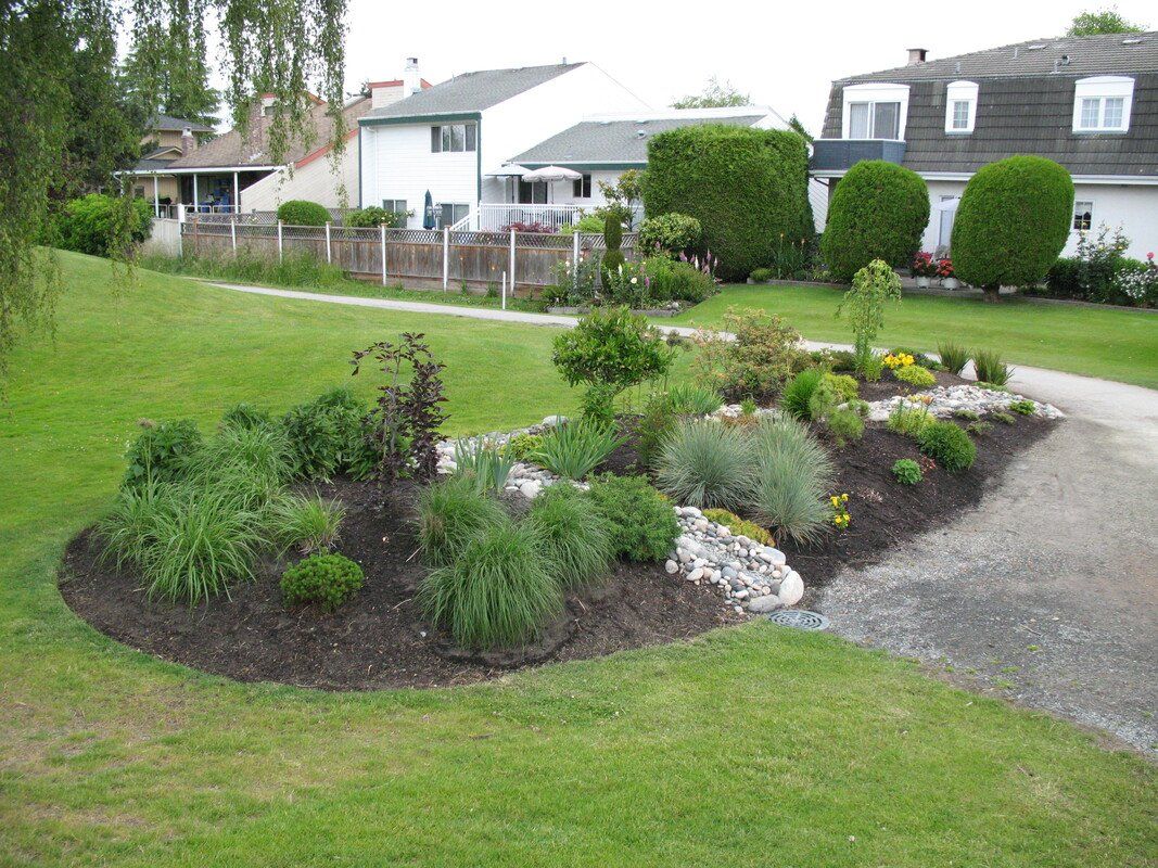 Commercial landscaping with flowers, shrubs, and bushes with French drain installed by Larix Landscape in Victoria, BC