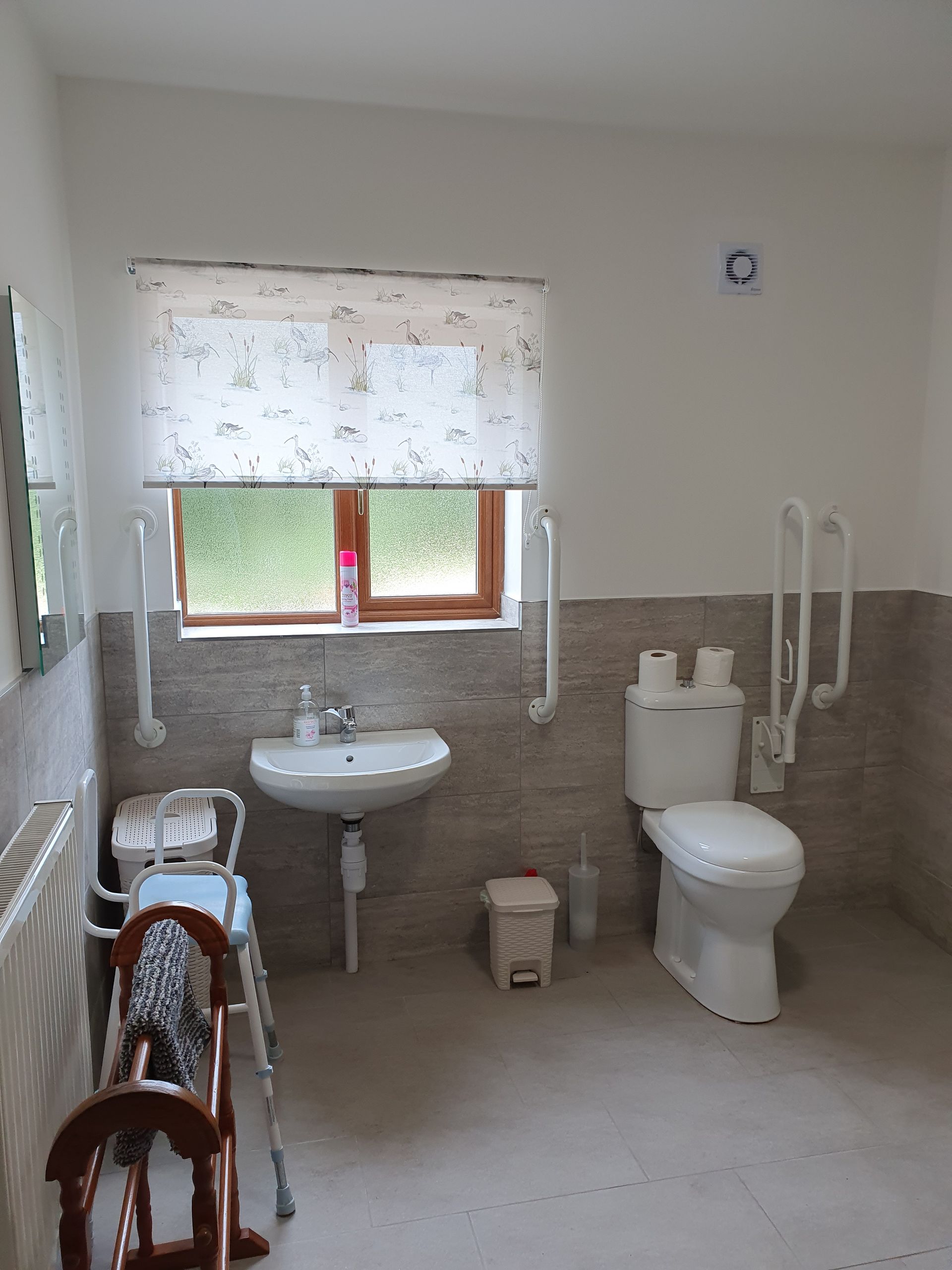 A bathroom with a toilet , sink and window