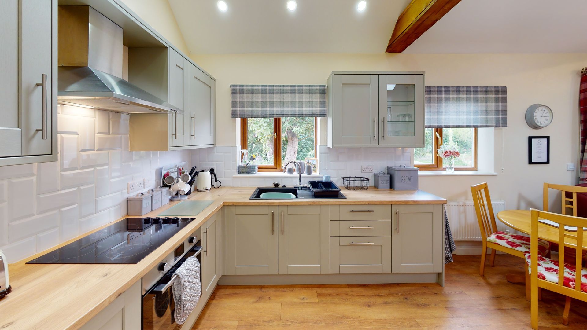 A kitchen with a stove , sink , cabinets and a dining room.